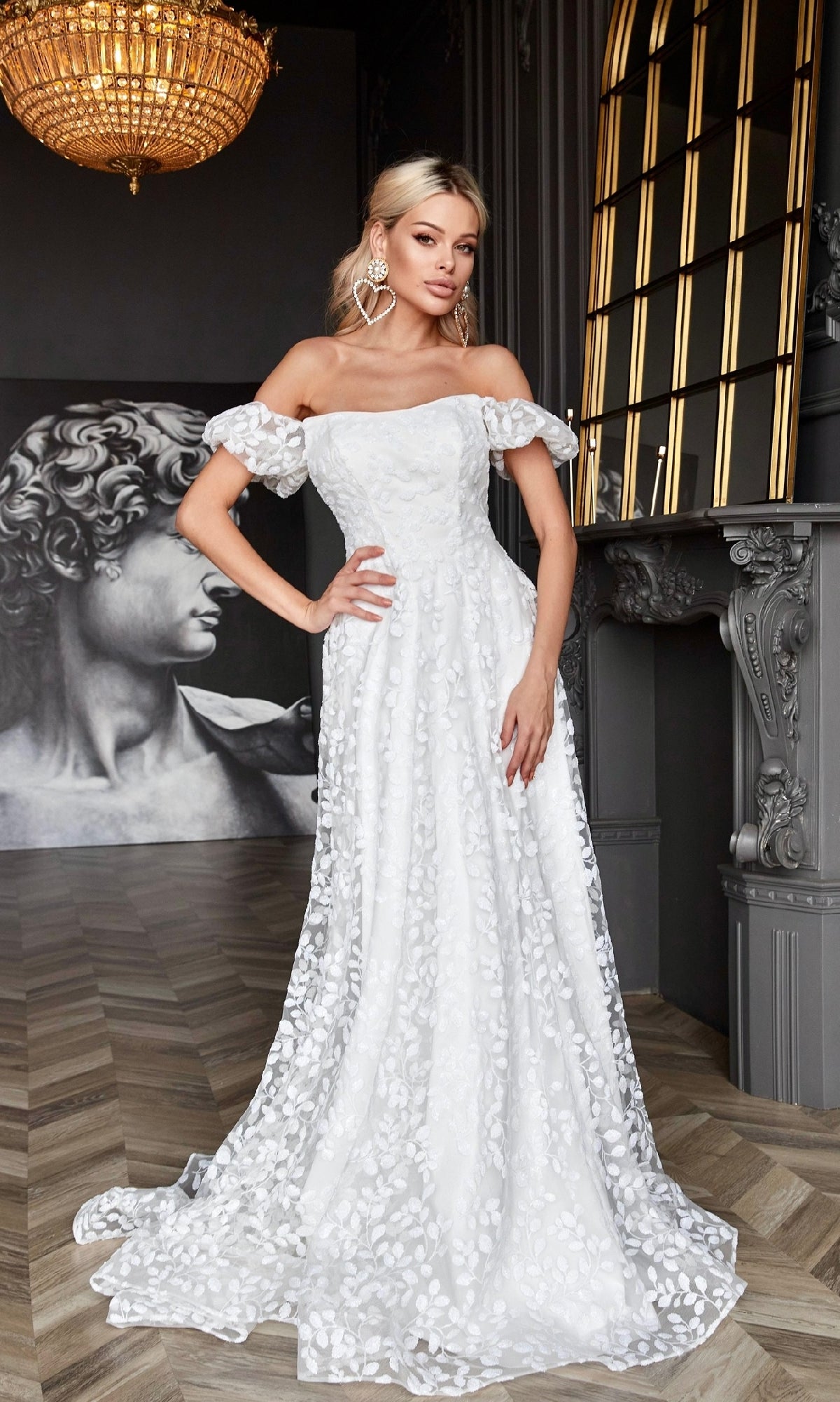 Wearing the Long White Lace Formal Dress: Tina Holly TK023W, a woman stands indoors near ornate decor and a large classical statue.